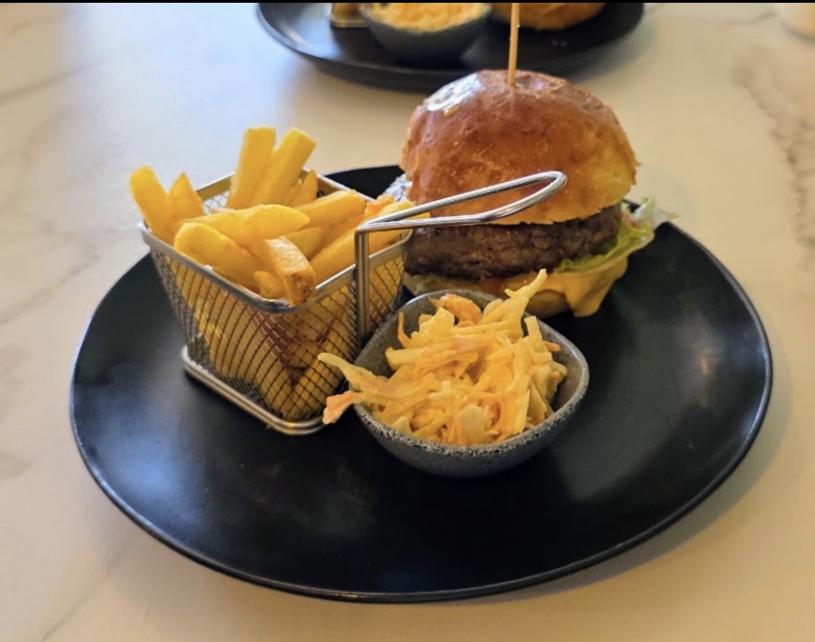 Gourmet burger with a basket of fries and coleslaw